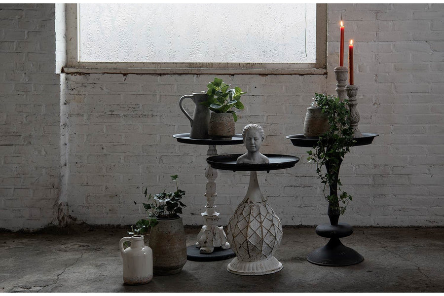 Antikolt felületű, fémből készült, fekete és krém színű lerakó kisasztal.