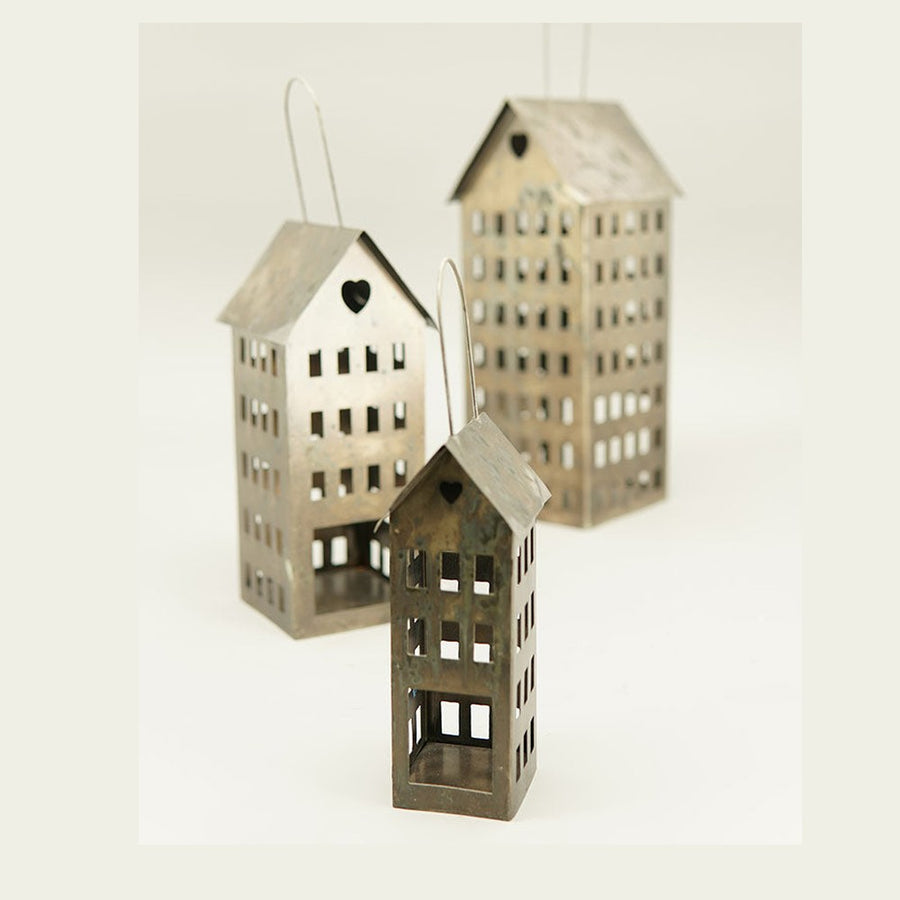 Antikolt felületű, rozsdás színű fémből készült, házikó formájú függeszthető karácsonyi mécsestartó.