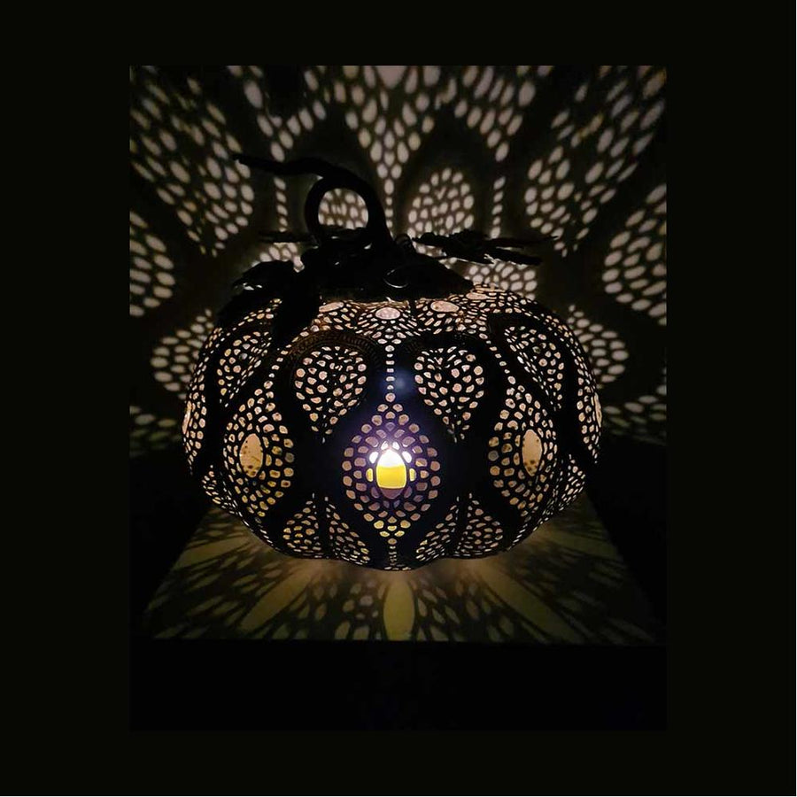 Fém töklámpás átvilágítva, csipke szerű árnyékkal a falon