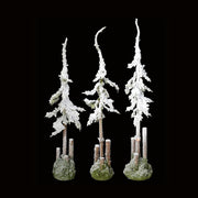 3 db, különböző méretű havas műfenyő fekete háttér előtt