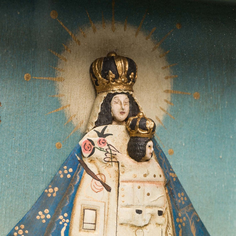 Szoborfülkés fa képkeretbe foglalt, az Irgalmas Szűzanyát ábrázoló figura.