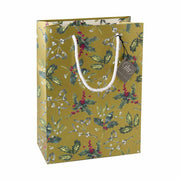 Fagyöngyággal és piros bogyós magyallal díszített, karácsonyi ajándéktasak.