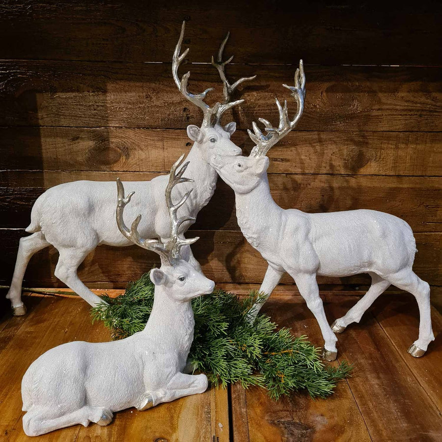 Glamour stílusú, fehér színű, deres hatású, ezüst agancsú és patájú exkluzív karácsonyi szarvas..