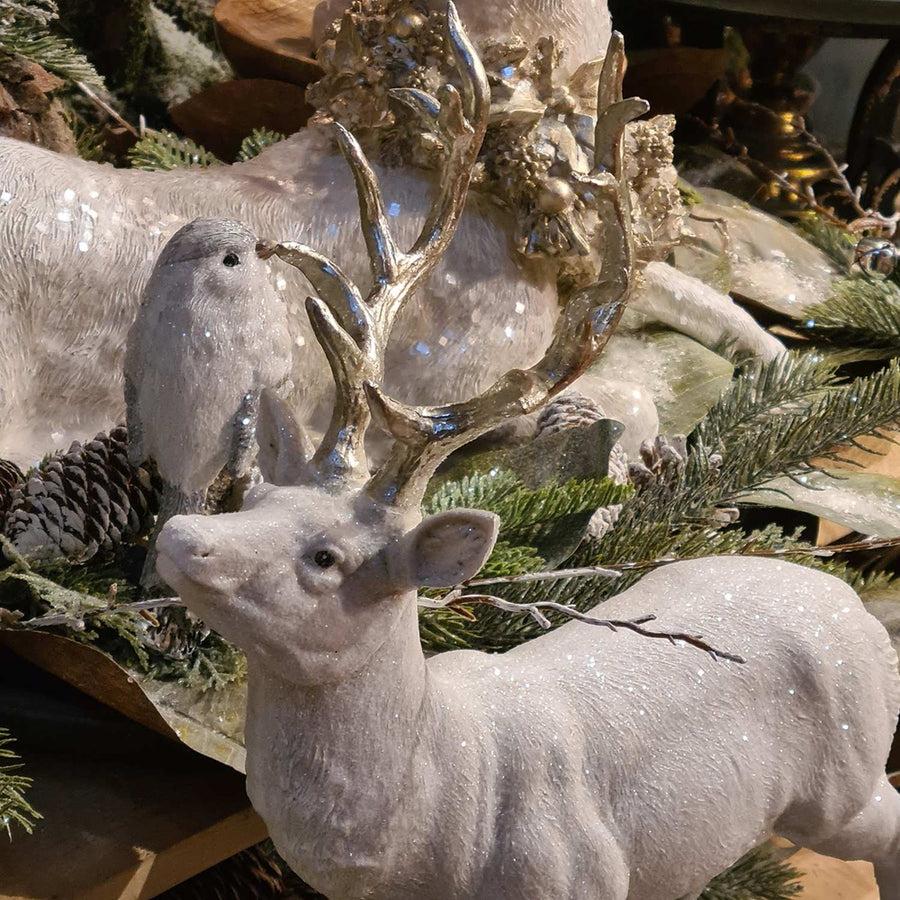 Glamour stílusú, fehér színű, deres hatású, ezüst agancsú és patájú exkluzív karácsonyi szarvas.