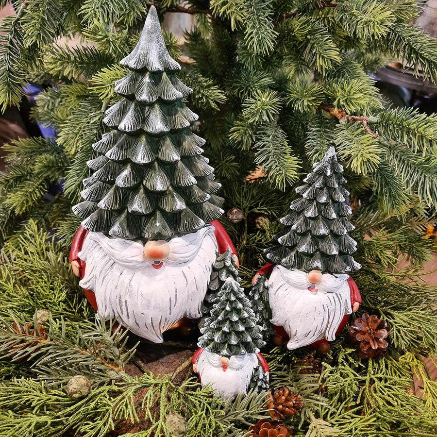 Karácsonyi manók fenyősapkában, zöld fenyők között.