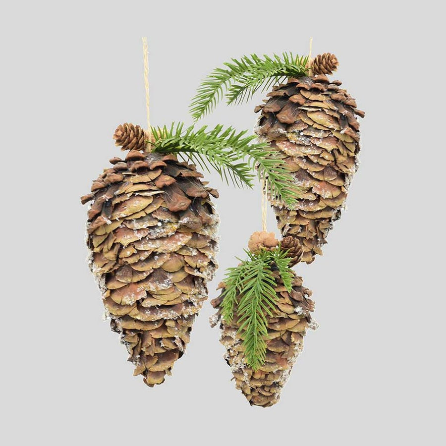 Fenyőággal és apró tobozokkal díszített, havas felületű, függeszthető karácsonyi toboz dísz..
