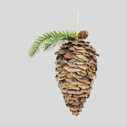 Fenyőággal és apró tobozokkal díszített, havas felületű, függeszthető karácsonyi toboz dísz-