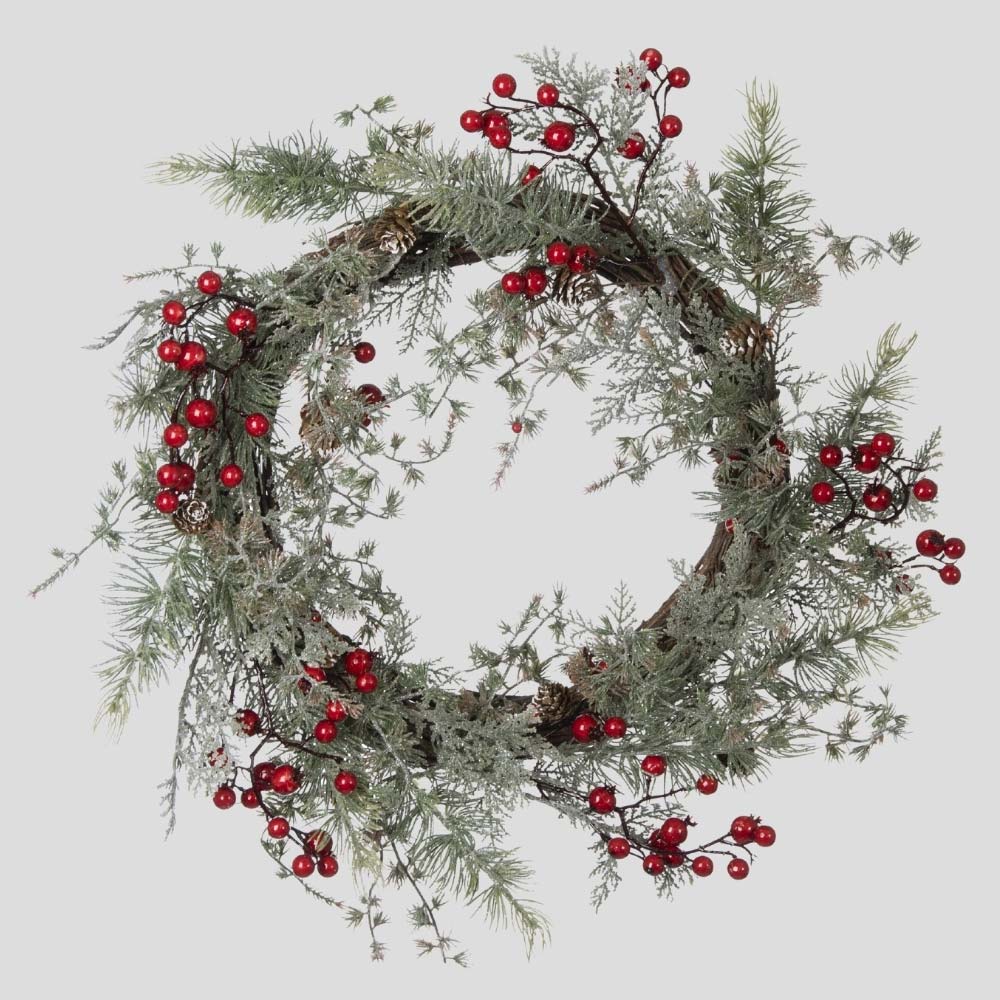 Piros bogyókkal díszített, ezüstös zöld színű mesterséges fenyőágakból készült karácsonyi koszorú, ajtódísz.