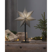 Szürke színű világító karácsonyi papírcsillag, ajándékokkal és fenyőággal.