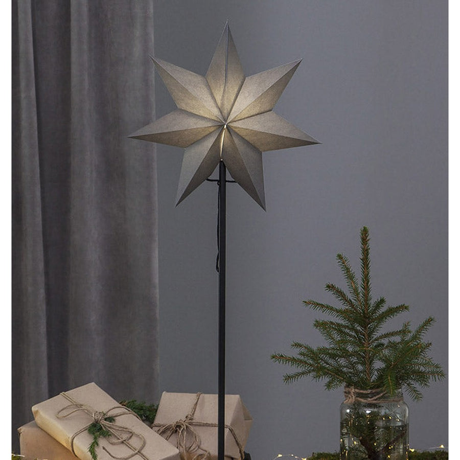 Szürke színű világító karácsonyi papírcsillag, ajándékokkal és fenyőággal. 