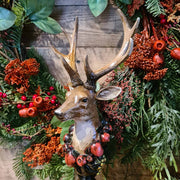 Vintage stílus, csipkebogyó koszorúval díszített, dekoratív karácsonyi szarvas mellszobor, erdei koszorúval.