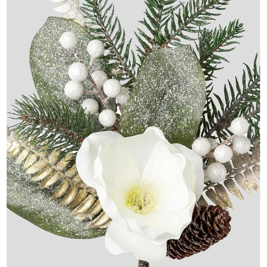 Fehér színű magnóliavirággal, pezsgőszínű páfrány levelekkel díszített, deres hatású fenyőág műnővény..