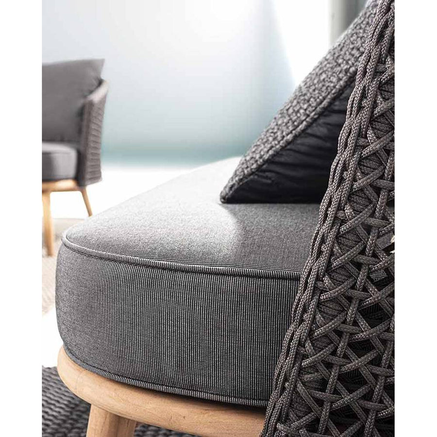 Prémium minőségű, természetes teakfa lábakon nyugvó, fekete színű sörűn szőtt polipropilén háttámlájú, 160 cm hosszú, formatervezett kortárs stílusú kerti kanapé, antracit szürke színű vízlepergető és UV-álló ülő és hátpárnával