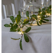 LED-es fagyöngy girland karácsonyi ünnepi asztalon.