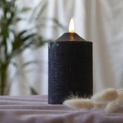 Fekete színű LED gyertya asztalon, száraz virágokkal.