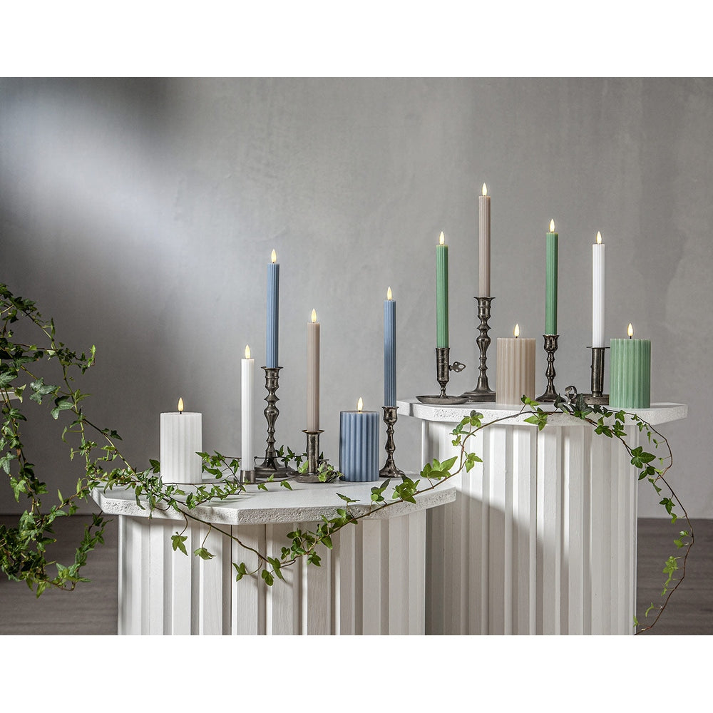 Stripe LED gyertya kollekció különböző méretű és színű valódi viaszból készült kannelúrás gyertyákkal, vintage gyertyatartókban elhelyezve, meleg fényű LED lánggal.