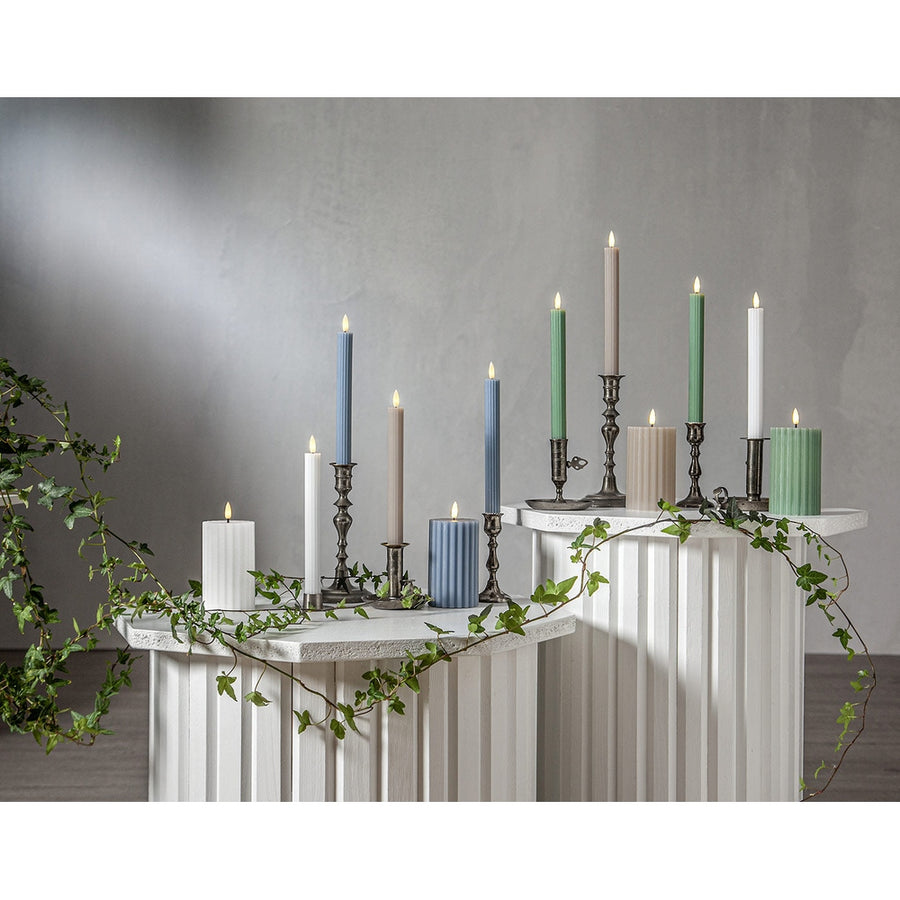 Stripe LED gyertya kollekció különböző méretű és színű valódi viaszból készült kannelúrás gyertyákkal, vintage gyertyatartókban elhelyezve, meleg fényű LED lánggal.
