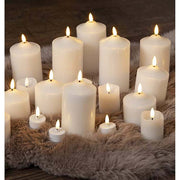 Fehér színű led gyertyák különböző méretben, szőrme szőnyegen , barna színű padlón