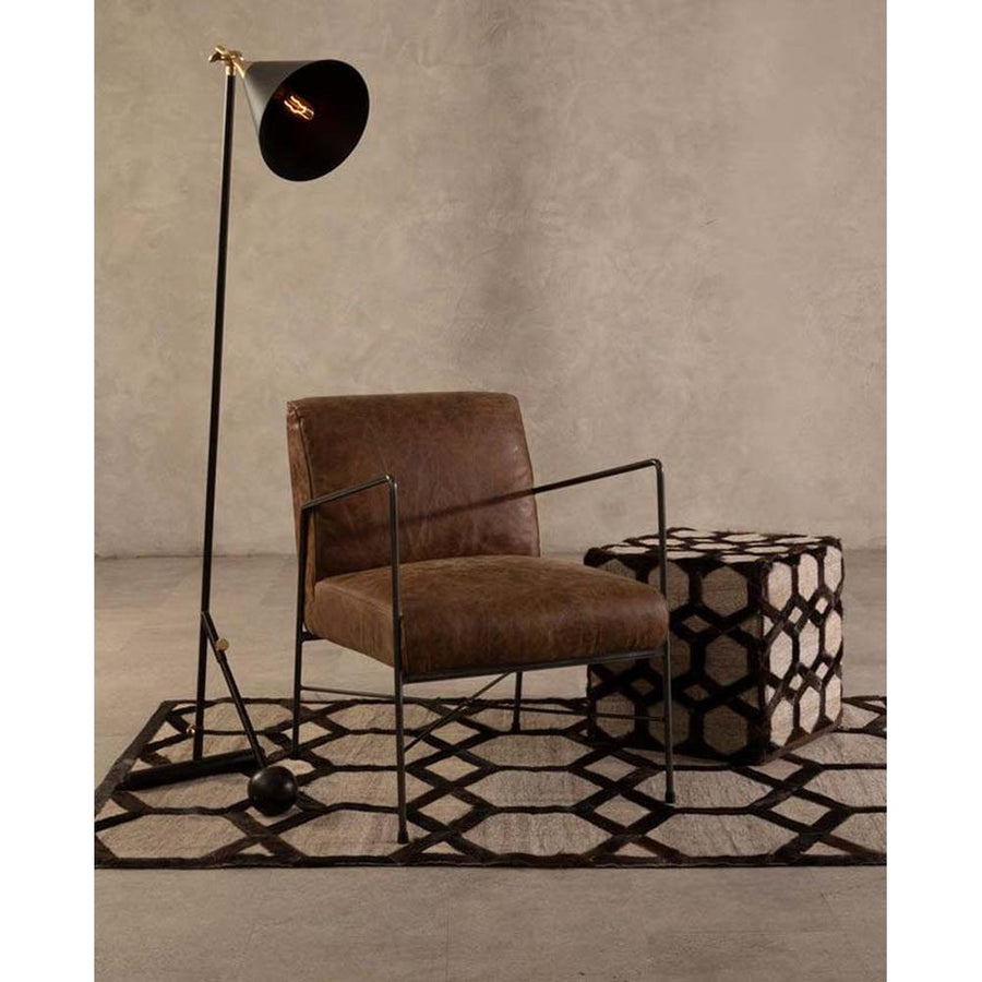 Natúr színű vasból készült, barna színű marhabőrrel kárpitozott, kortárs-loft stílusú, formatervezett prémium karosszék., modern állólámpával szürke színű bemutatóteremben. 