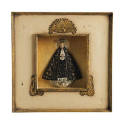 Szoborfülkés fa képkeretbe foglalt, a Magányos Szűzanyát ábrázoló figura.