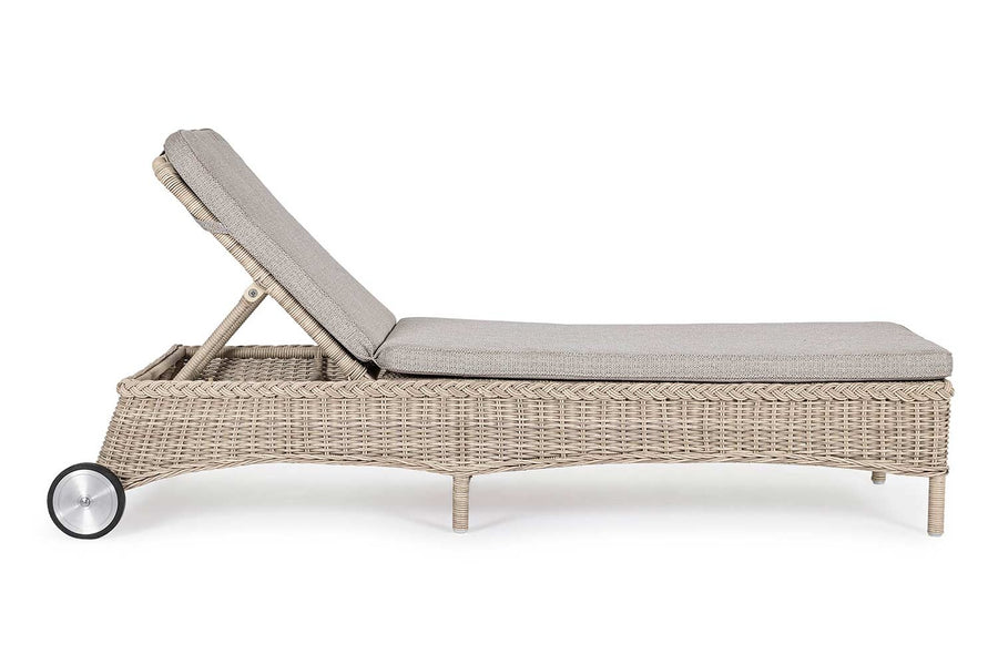 Vidéki vintage stílusú, kerekekkel felszerelt,, dönthető háttámlájú, natúr színű műrattan napozóágy, bézs színű olefin fekvőpárnával,