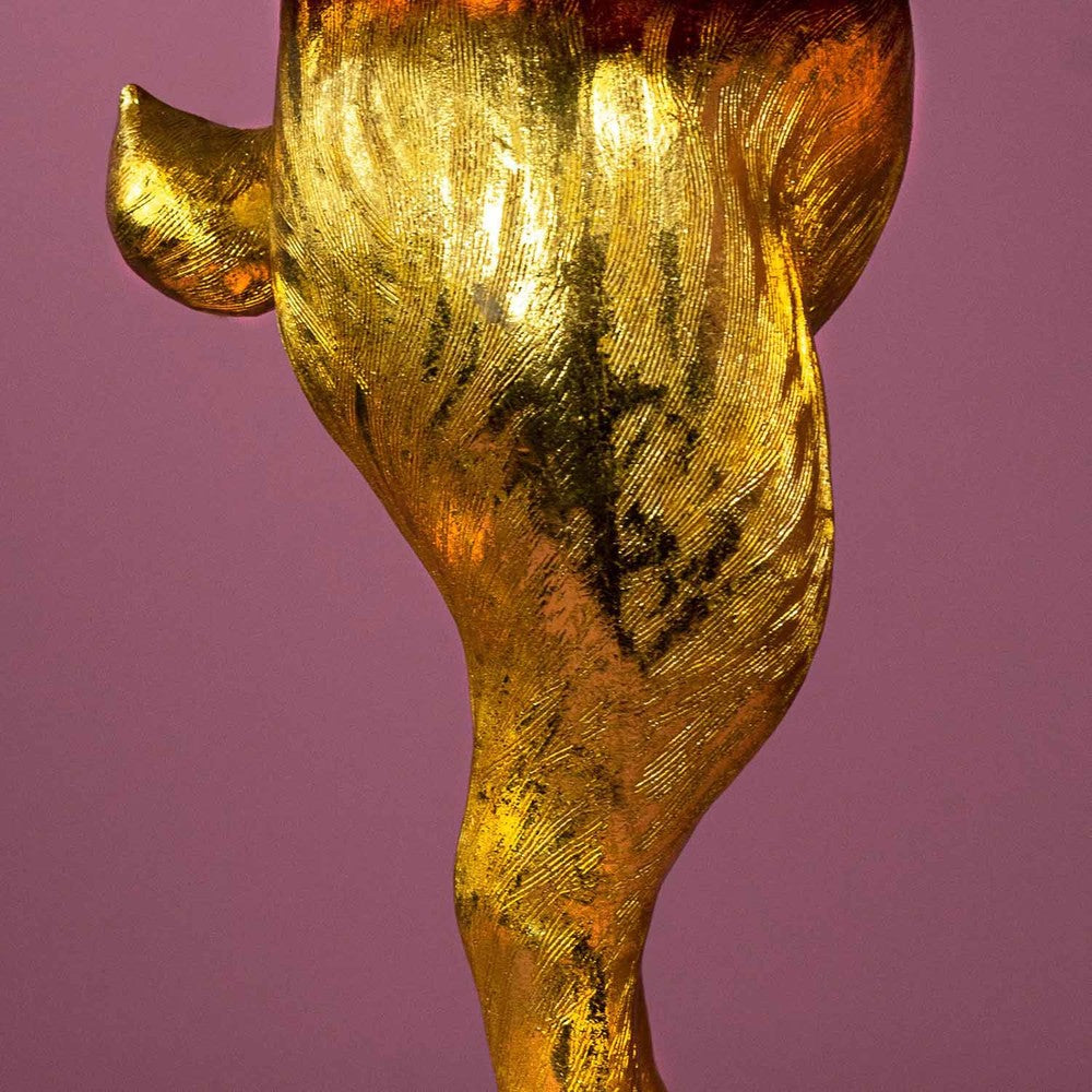 Aranyszínű, rejtőzködő nyuszi figurás, 74 cm magas, kortárs, glamour stílusú, díjnyertes dizájn asztali lámpa, türkizszínű lámpaernyővel, mályva színű fal előtt.