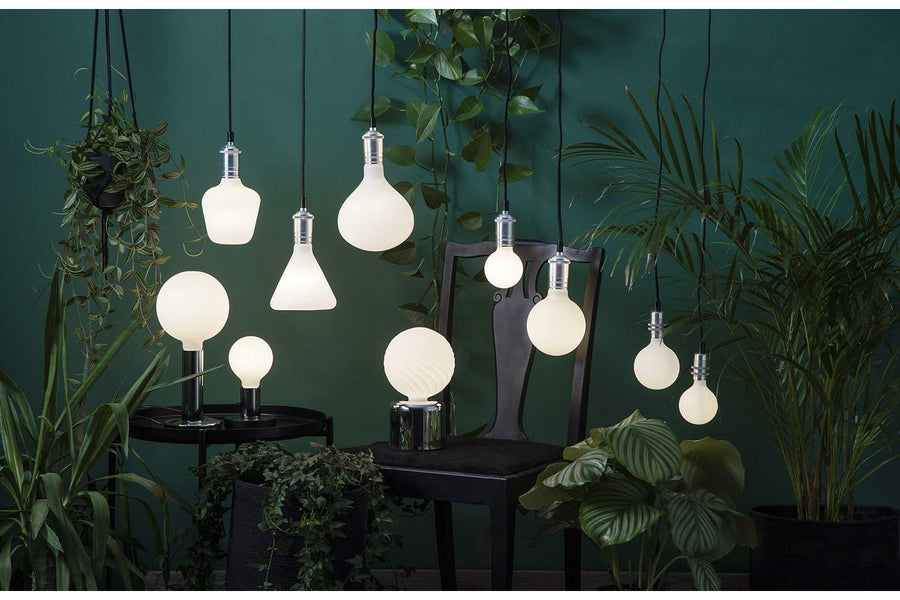 Matt felületű opál LED izzók zöld növények között.