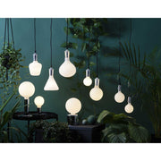 Matt felületű opál LED izzók zöld növények között.