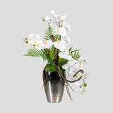 Fehér színű mű orchidea kompozíció, ezüst színű fém vázában.