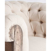 Prémium kategóriás, gyarmati stílusú, újrahasznosított trópusi fából készült, tört fehér színű szövettel kárpitozott fotel karfájának közeli képe