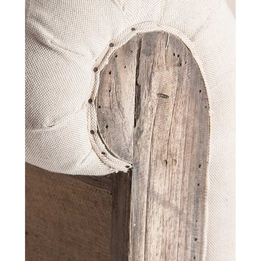 Prémium kategóriás, gyarmati stílusú, újrahasznosított trópusi fából készült, tört fehér színű szövettel kárpitozott fotel karfájának közeli képe