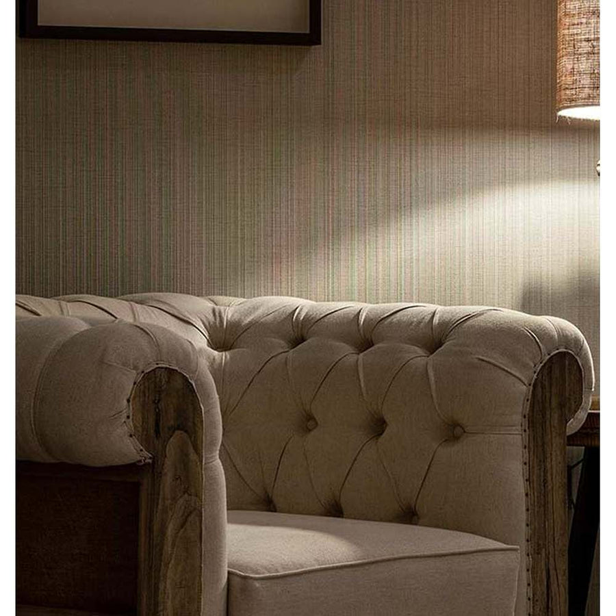 Prémium kategóriás, gyarmati stílusú, újrahasznosított trópusi fából készült, tört fehér színű szövettel kárpitozott fotel csíkos fal előtt 