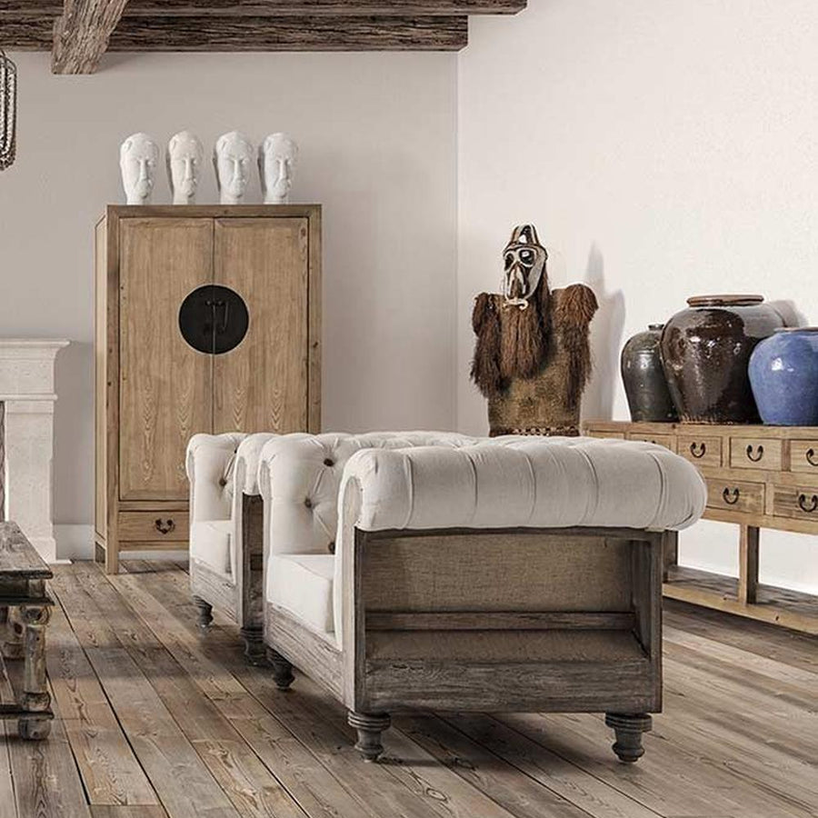 Prémium kategóriás, gyarmati stílusú, újrahasznosított trópusi fából készült, tört fehér színű szövettel kárpitozott fotelek vidéki stílusú nappaliban, deszka padlón , gerendás mennyezettel 