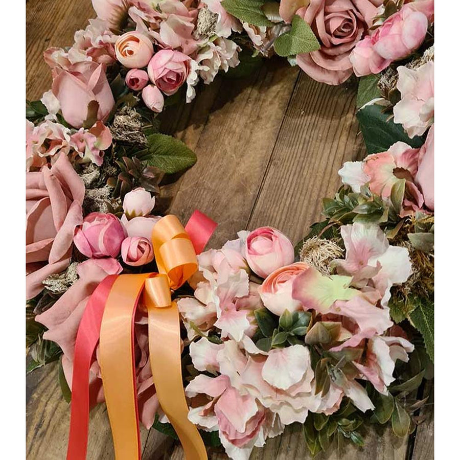 Élethű mesterséges művirágokból készült, szaténszalagokkal díszített nagyméretű ajtókopogtató koszorú