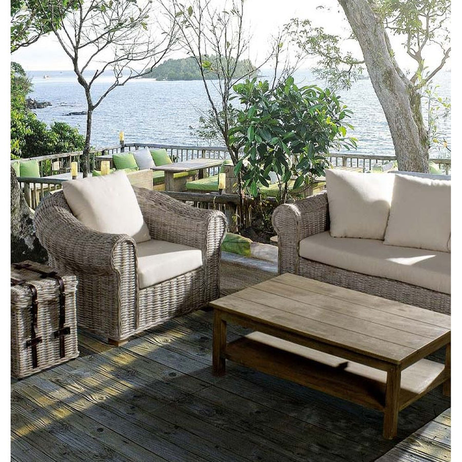 Tengerparti teraszon álló mediterrán stílusú rattan fotel és kanapé.