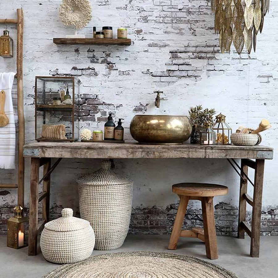 Tropical, illetve modern Art Deco stílusú függeszték lámpa, antikolt réz színű, áttört mintázatú fém levelekkel, enteriőrben bútorokkal, fehér téglafal előtt