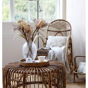 Vintage stílusú állólámpa, antikolt réz színű fém lámpabúrával, enteriőrbe helyezve,, bambusz hintaszékkel és bamusz dohányzóasztallal  