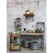 Rusztikus fa asztal bádog kaspókkal és gurítható bambusz asztalkával.