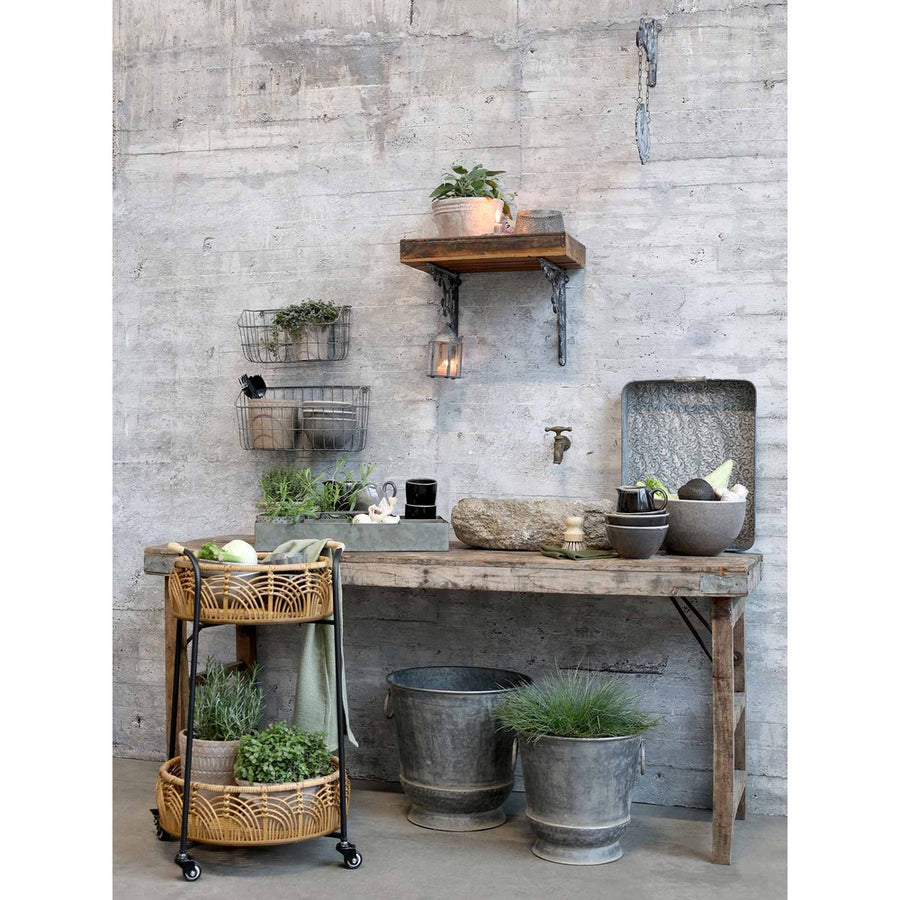 Rusztikus fa asztal bádog kaspókkal és gurítható bambusz asztalkával.