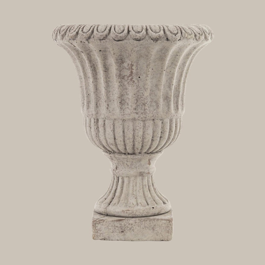 Antikolt felületű, szürke színű talpas cement kaspó.