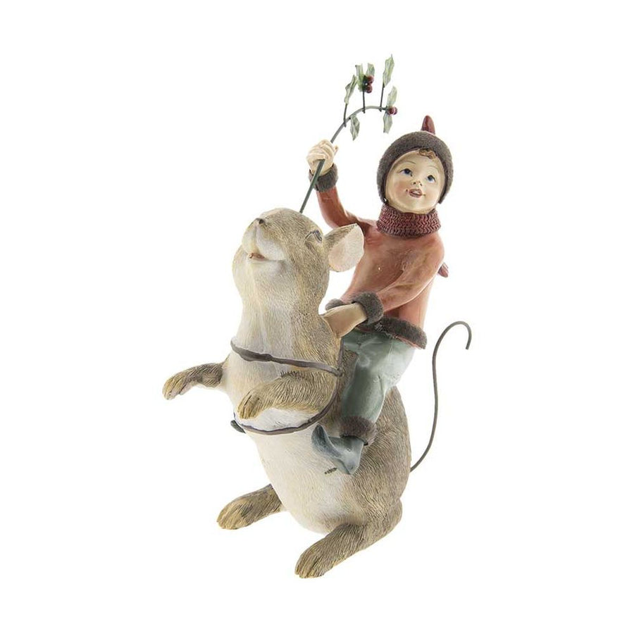 Barna színű erdei egér hátán utazó karácsonyi manó bordó ruhában és sállal, kezében magyallal szemből fotózott képe