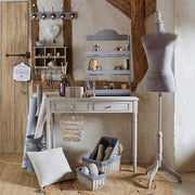 Vintage falifogas, vidéki nappaliban, próbababával, íróasztallal és kosarakkal. 