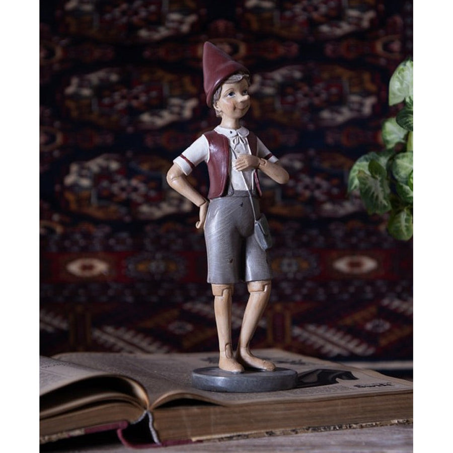 Vintage stílusú, tarisznyát viselő Pinokkió-figura.